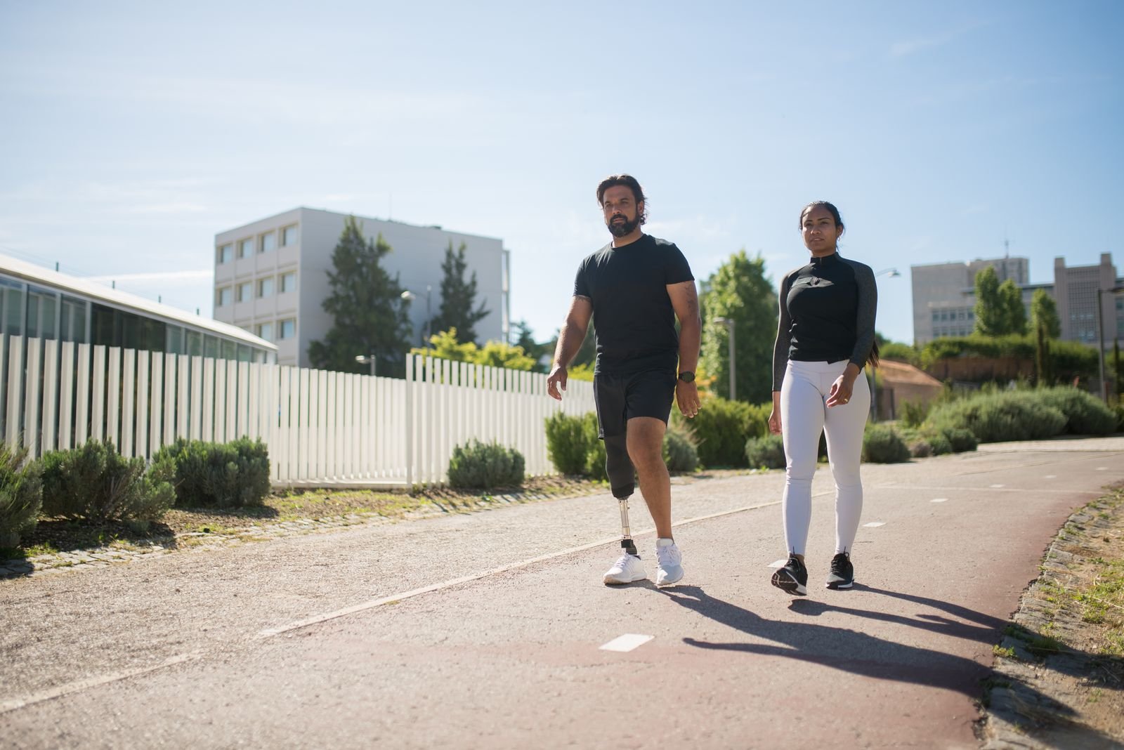 A man walking outdoors on a below-knee prosthesis.